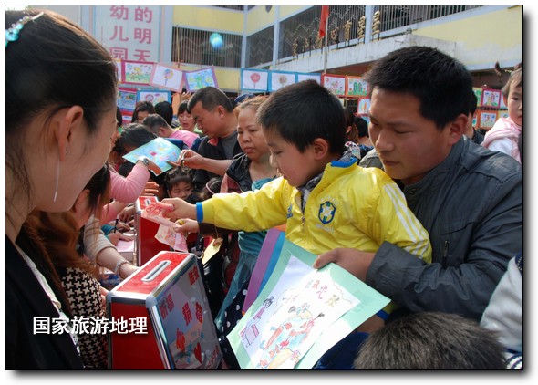 4月27日，婺源縣星星幼兒園的小朋友們?cè)诩议L(zhǎng)的陪同下將愛心義賣的錢進(jìn)行募捐。