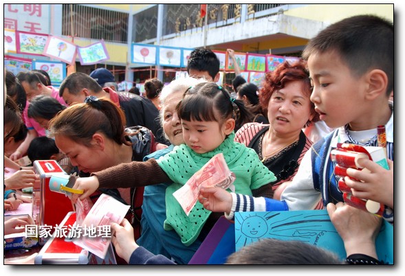 4月27日，婺源縣星星幼兒園的小朋友們?cè)诩议L(zhǎng)的陪同下將愛心義賣的錢進(jìn)行募捐。