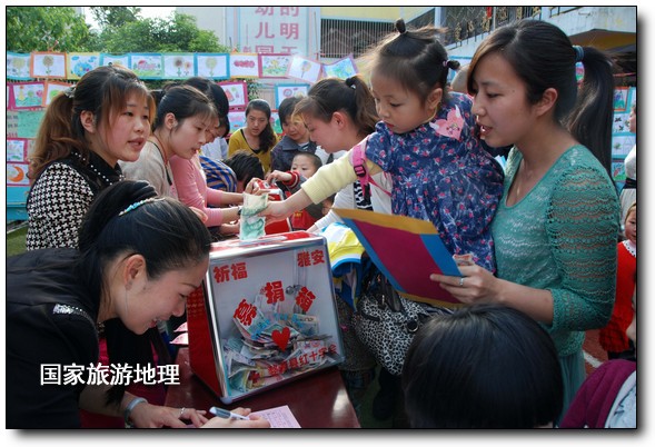 4月27日，婺源縣星星幼兒園的小朋友們?cè)诩议L(zhǎng)的陪同下將愛心義賣的錢進(jìn)行募捐。