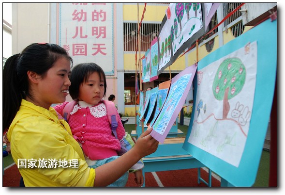 4月27日，婺源縣星星幼兒園的小朋友們?cè)诩议L(zhǎng)的陪同下在挑選愛心義賣的作品。